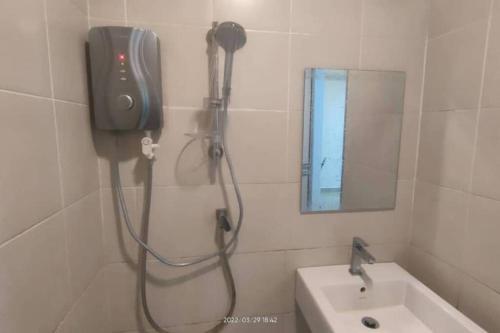 a shower in a bathroom with a sink and a mirror at SGA SuriaJelutong in Shah Alam