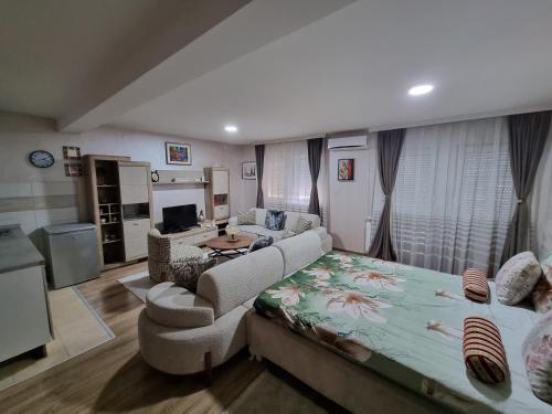a living room with a large bed and a couch at Avio Lux Apartmani in Novi Pazar