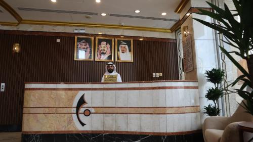 a man standing behind a counter in a room at Al Mokhtara Diamond in Al Madinah