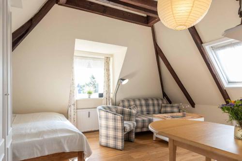 un soggiorno con un letto e un divano di Sylter Wohlfühlnest, App 2 a Wenningstedt