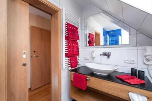 a bathroom with a sink and red towels at Ferienwohnungen Engelmannstift in Bacharach