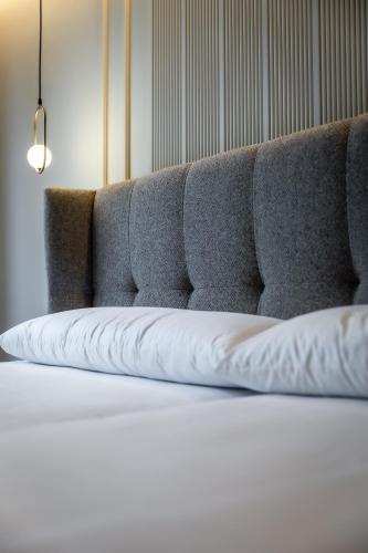 a close up of a bed with a gray couch at HOTEL CORONA DE PADRÓN in Padrón