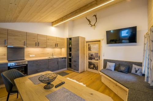 a kitchen and living room with a table and a couch at Kummererhof in Itter