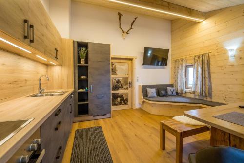 a kitchen with a sink and a couch in a room at Kummererhof in Itter