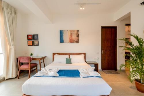 a bedroom with a bed and a table at HideAway 2BHK Villa Style Apartment - Stay To Unwind in Old Goa