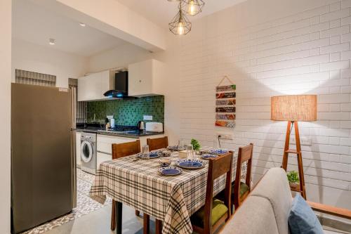 a dining room with a table and a kitchen at HideAway 2BHK Villa Style Apartment - Stay To Unwind in Old Goa