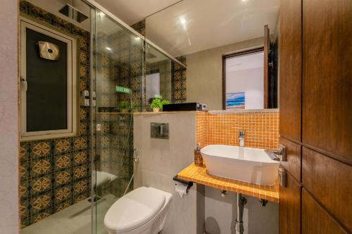 a bathroom with a toilet and a sink and a shower at HideAway 2BHK Villa Style Apartment - Stay To Unwind in Old Goa