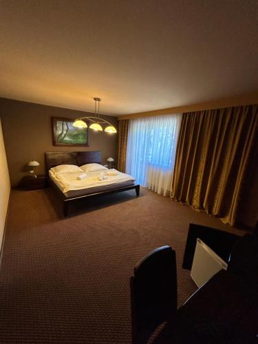 a hotel room with a bed and a window at Penzion Benedikti in Prievidza