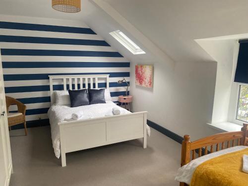 a bedroom with a blue and white striped wall at Large Townhouse Penarth, Cardiff in Cardiff