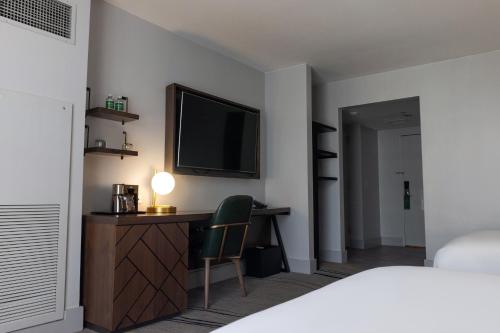 a bedroom with a desk with a television and a bed at The Starling Atlanta Midtown, Curio Collection by Hilton in Atlanta