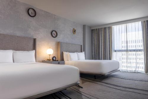 a hotel room with two beds and a large window at The Starling Atlanta Midtown, Curio Collection by Hilton in Atlanta