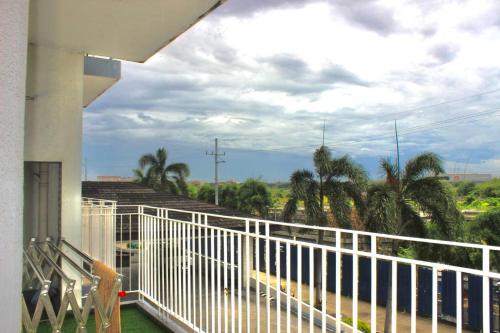a balcony with a white railing and palm trees at La Vida Hermosa in Manila