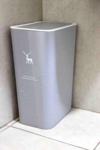 a grey trash can with a deer sticker on it at La Vida Hermosa in Manila