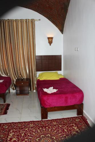 a bedroom with a bed with a red and yellow blanket at Nile View Guest House in Aswan