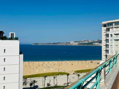 a view of the beach from the balcony of a building at Luxueux Appartement centre et plage & wifi ! in Tangier