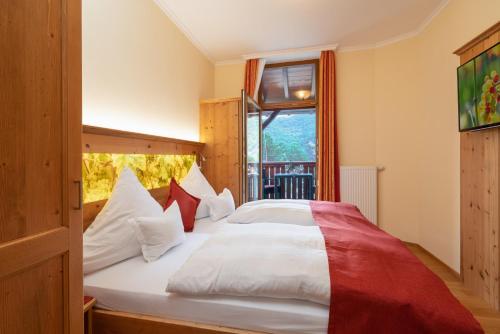 sypialnia z łóżkiem z białymi i czerwonymi poduszkami w obiekcie Ferienwohnungen Engelmannstift w mieście Bacharach