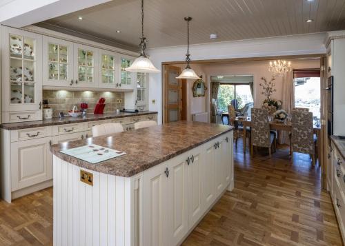 a kitchen with white cabinets and a large island at Hillcrest in Fort William