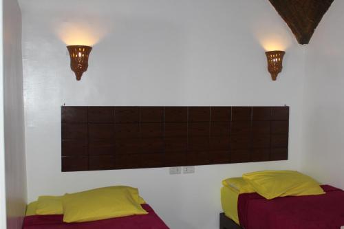 a bedroom with two beds and two lights on the wall at Nile View Guest House in Aswan