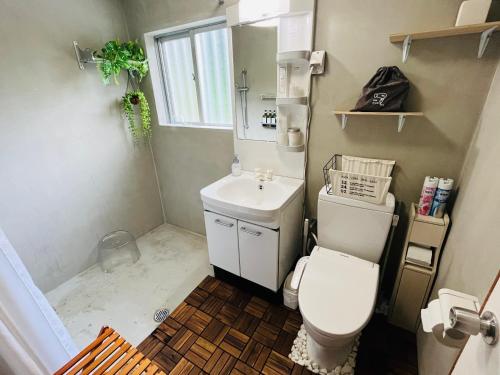 a small bathroom with a toilet and a sink at Lodge Crea in Ujimi