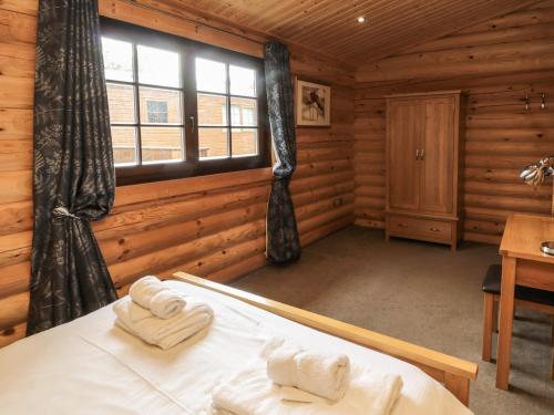 a bedroom with a bed in a log cabin at Welcome Hjem Log Cabin in Morpeth