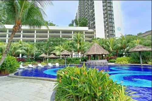 un complejo con una piscina con sillas y un edificio en Johor Bahru Central Park/15分钟到达很多地方，完美的市中心地点, en Johor Bahru