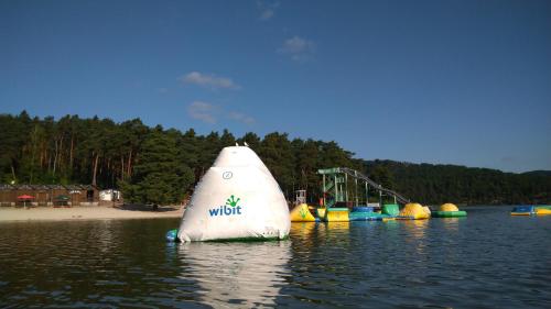 a white sail boat in the water next to a beach at Rezidence Fami Deluxe Design in Staré Splavy