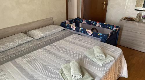 a bedroom with a bed with two towels on it at Rose e Frutta - Yellow Daisy in Ronchi dei Legionari