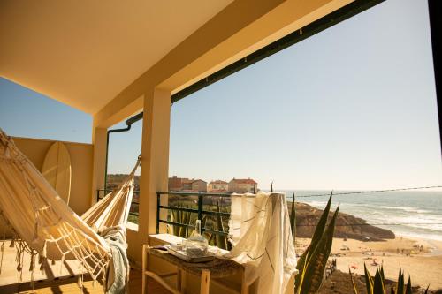 eine Terrasse mit Hängematten und Strandblick in der Unterkunft Agua de Madeiros - Vista do mar in Pedra Do Ouro