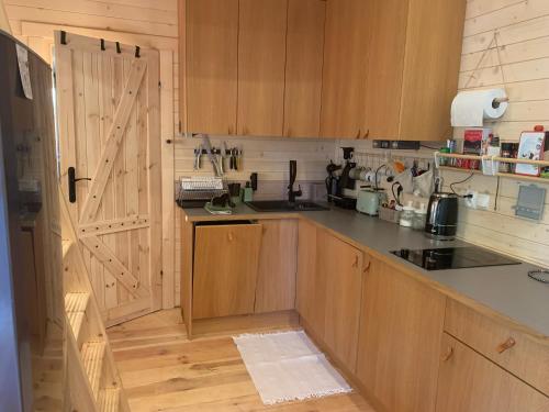 a kitchen with wooden cabinets and a sliding door at DZIK Łupawsko in Łupawsko