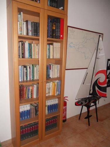 a book shelf filled with books and a toy sailboat at Glaros Studios in Loutra Edipsou