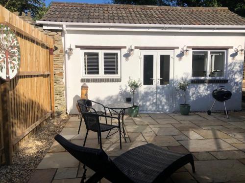 a patio with chairs and a table in front of a house at Olli's Cottage-Terrace & Jacuzzi in Bristol