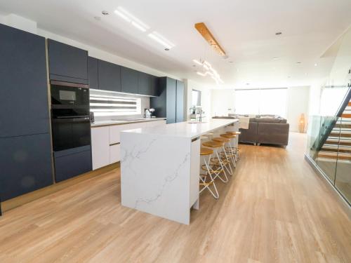 a kitchen with a white island in a room at The Dunes in Llandudno