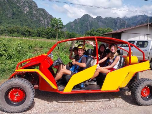 grupa ludzi siedzących w samochodzie ATV w obiekcie Vang Vieng Chill House w mieście Vang Vieng