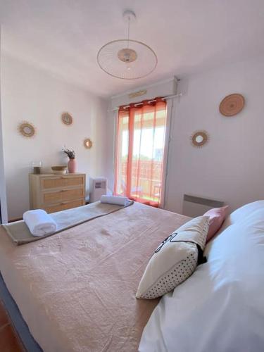 un grand lit dans une chambre avec une fenêtre dans l'établissement Cocon aux portes du centre ville avec terrasse, à Avignon