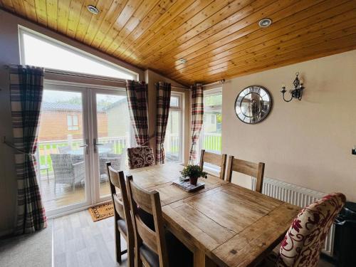 a dining room with a wooden table and chairs at Crystal Lodge with Hot Tub in Malton