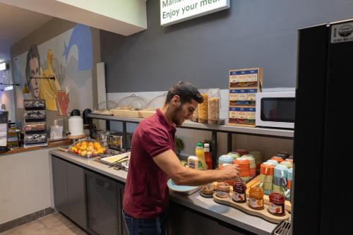 a man standing in a kitchen preparing food at a&o München Hauptbahnhof in Munich