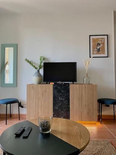 un salon avec une table et une télévision dans l'établissement Cocon aux portes du centre ville avec terrasse, à Avignon