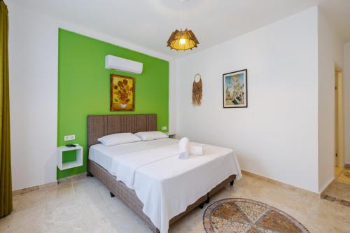 a bedroom with a bed with a green wall at Mel Town in Antalya