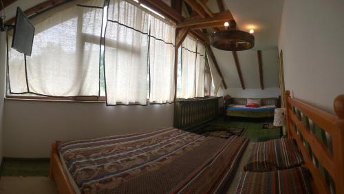 a bedroom with a large bed with a window at Casa Moeciu Family in Moieciu de Jos