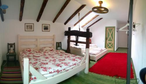 a bedroom with two beds and a red rug at Casa Moeciu Family in Moieciu de Jos