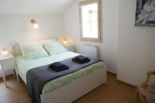 - une chambre avec un lit et 2 serviettes noires dans l'établissement Les Plaisirs dIrleau, à Le Vanneau