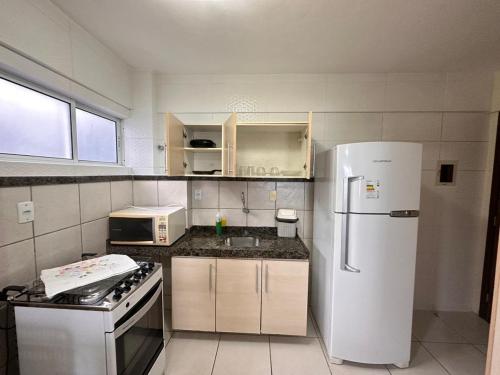 uma cozinha com um frigorífico branco e um fogão em Terrazzo Ponta Negra Flat em Natal