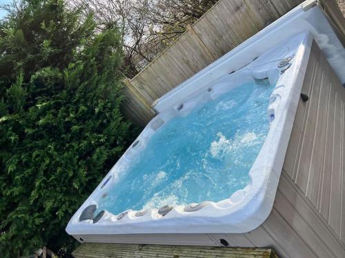 a swimming pool on the side of a fence at 10 sleeper beautiful house with 8 seat hot tub! in Durley