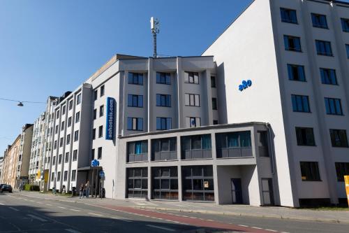 a large white building on a city street at a&o München Hackerbrücke in Munich