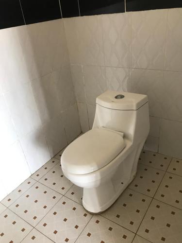 ein Bad mit einem weißen WC in einem Zimmer in der Unterkunft The Fortuna Apartment in Kabale