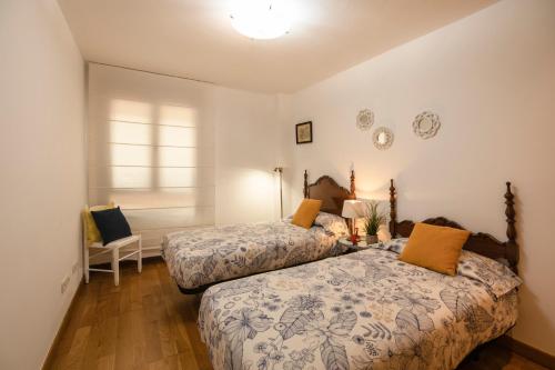 una camera con due letti e un tavolo con una sedia di Gran Canaria suite a Las Palmas de Gran Canaria