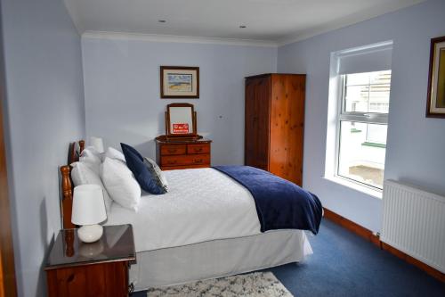 um quarto com uma cama e uma janela em Simply Donegal Adrihidbeg Cottage em Dungloe