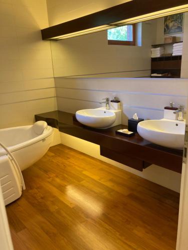 a bathroom with two sinks and a toilet at Aquincum Dunaparti Apartman in Budapest