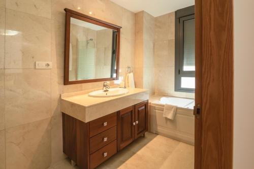 La salle de bains est pourvue d'un lavabo, d'un miroir et d'une baignoire. dans l'établissement Gran Canaria suite, à Las Palmas de Gran Canaria