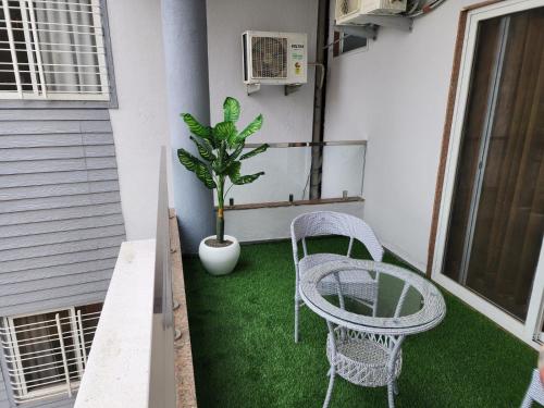 a patio with two chairs and a potted plant at Dnyanprabha Executive in Tuljapur